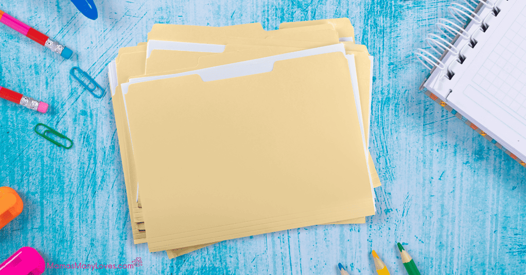 Manila folders for school papers on blue background with school notebook, pencils and paperclips
