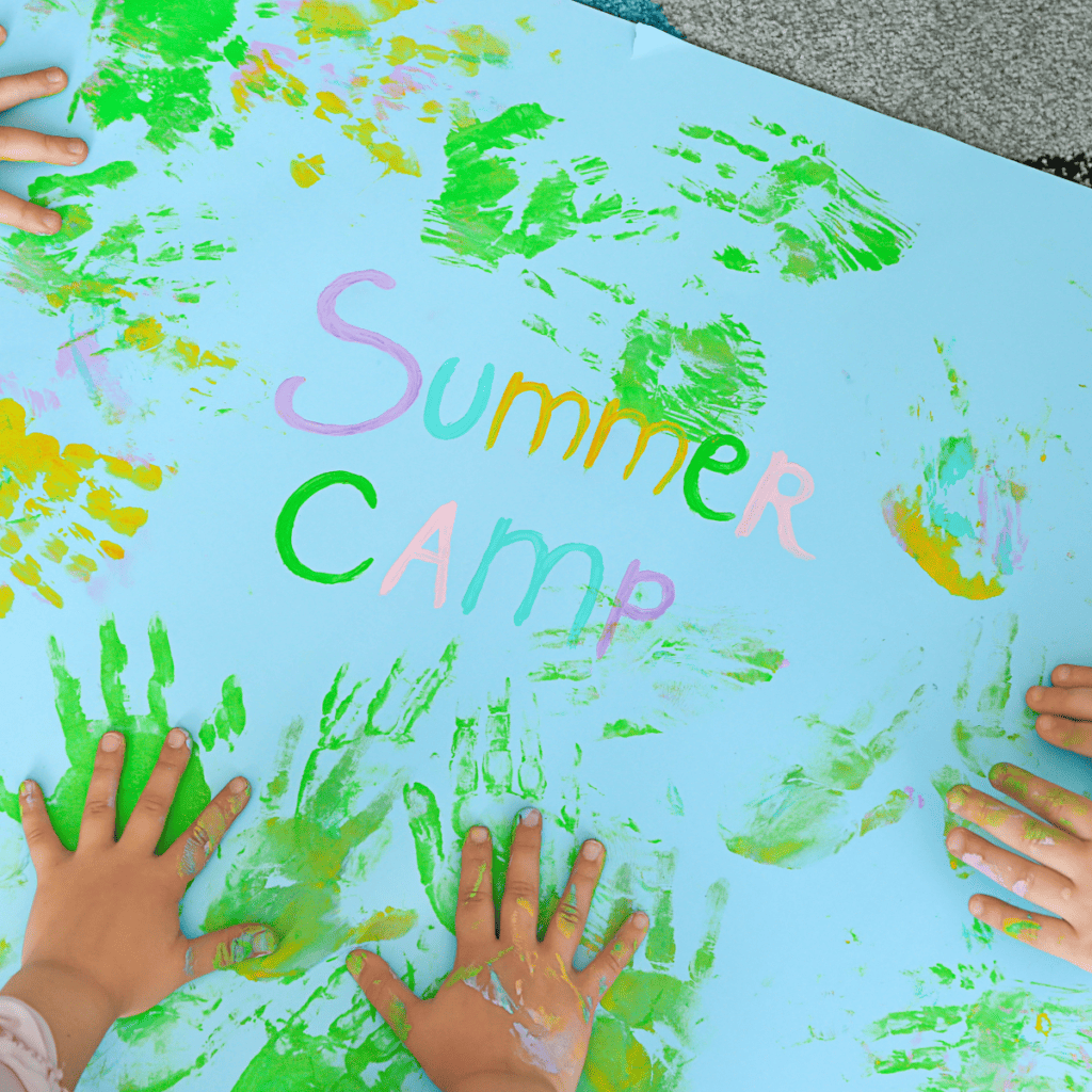 Photo of kids handprints with "Summer Camp" written in the middle