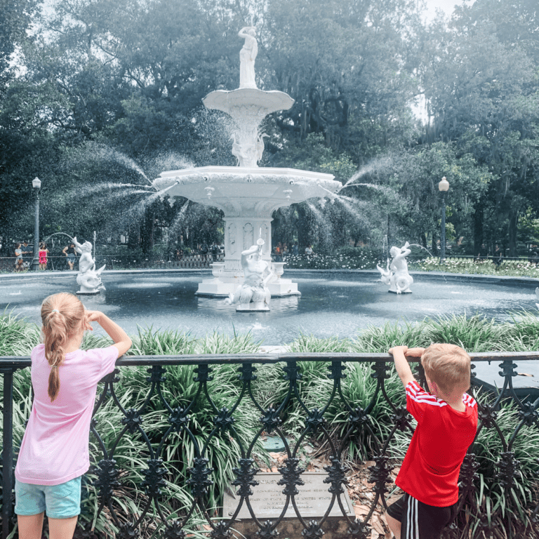 Photo of two children standing in front of the Forsyth Park Fountain in Forsyth Park located in Savannah, Georgia