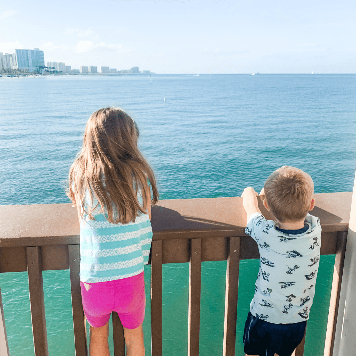 Photo of two kids on Pier 60 in Clearwater Beach, Florida looking out over the Gulf of Mexico.